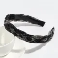 Gedetailleerde close-up van de zwarte strass-gevlochten haarband met fijne textuur. - Zwart