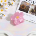 Vista detallada de una linda pinza para el cabello de flor rosa con centro amarillo diario. - Flor Pequeña