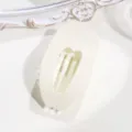 Vista dettagliata del mollettone per capelli ovale piatto a cuore in tonalità beige crema. - Bianco