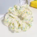 Detailed view of a sweet yellow floral lace scrunchie, perfect for cute daily hair styling. - Yellow Round Floral