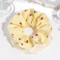 Closeup detail of yellow gingham cherry print hair scrunchie with white lace layer trim. - Yellow Cherry