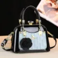 Borsa a mano in pelle verniciata nera con tasca monogram blu, dettagli dorati e chiusura in cristallo. - Blu