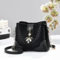 Borsa a secchiello nera con elegante motivo a stelle, catena dorata e ciondolo a fiocco. - Nero