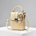 Beige geweven mini box tas, stijlvolle schoudertas van stro met handvat en leuk bloemhangertje. - Abrikoos