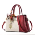 Red and off-white embossed women handbag with silk scarf and leaf pendant for daily use. - White & Red