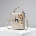 Mini geweven doos schoudertas met lederen flap, vintage metalen slot en leuke bloemhanger. - Khaki
