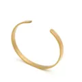 Détail de bracelet jonc ouvert en acier titane doré minimaliste avec surface polie lisse. - Rose