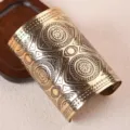 Large bracelet manchette rigide en métal doré avec motif géométrique complexe gravé. - Style Jonc Large en Relief / Or