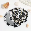 Detail view of a black and white shell folding makeup mirror, compact and portable design. - Black and White