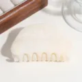 Gedetailleerde close-up van de halfronde haarhaak met prachtig marmerpatroon design. - Beige