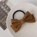 Close-up van een bruine fluwelen strik haarelastiek op een bord, stijlvol najaar. - Koffie