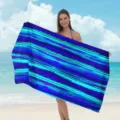 Vista dettagliata di un morbido telo mare in microfibra con righe acquerello blu e turchese. - Asciugamani da spiaggia in microfibra - 14