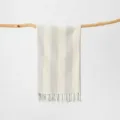 Primo piano dettagliato del telo mare in cotone a righe con tessitura morbida e frange. - 100x180cm+Nappa / Asciugamano turco grigio a righe verticali