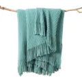 Detailed view of soft cyan knitted throw blanket featuring elegant fringe edges and textured stripes. - Striped Warp Knit - Lake Green / 127*152+10cm Fringes