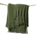 Olive green knitted throw blanket with fringe draped on branch for sofa living room decor - Striped Warp Knit - Dark Green