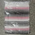Detail view of woven Mexican style blanket with colorful stripes and fringe tassels. - MC Pink