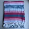 Close-up detail of the woven Mexican blanket showing colorful stripes, geometric patterns, and fringe. - Rose Pink