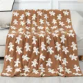 Detailed view of cozy brown fleece throw blanket with cute white gingerbread man holiday pattern. - Gingerbread Man - Khaki