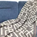 Detailed shot of a soft woven jacquard throw blanket with geometric pattern on a cozy blue sofa. - Floral Multi-Color Stripes