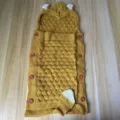 Detailed view of knitted baby sleeping bag, mustard yellow anti-kick blanket with cute ears. - Turmeric