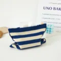 Detalle de funda de pañuelo tejida a rayas, bolsa de algodón para mesa de centro. - Rayas horizontales azules y blancas