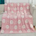 Gemütliche rosa flauschige Kuscheldecke mit weißem Smiley-Gesicht für das Wohnsofa. - Rosa