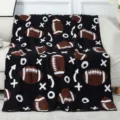 Dettaglio coperta soffice fantasia football, plaid lavorato a maglia jacquard per divano. - Palla da rugby / Caffè Nero