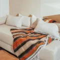 Handmade woven Mexican blanket with fringe, colorful striped design for sofa and beach. - Camel