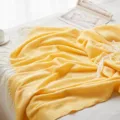 Close-up detail of yellow chevron knit throw blanket showing soft herringbone texture and fringe. - Big Wave - Yellow