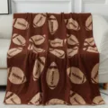 Coperta in peluche marrone con classico motivo da football, morbida e comoda per il divano. - Palla da rugby / Caffè Riso