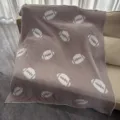 Cozy taupe fuzzy throw blanket featuring a fun white football pattern, perfect for sofa styling. - Rugby Ball / Khaki