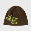 Close-up view of the knitted beanie showcasing the contrast lime green letter graphic. - Coffee