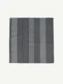 Close-up detail of the stylish geometric pattern, vertical stripes, and polka dots on a chic scarf. - Black