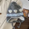 Detailed view of the cute grey knit earflap hat featuring sweet strawberry jacquard and pom-pom. - Gray