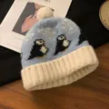 Hübsche Winter-Strickmütze mit niedlichem Pinguin-Muster und weißem Bommel sowie Krempe. - Blauer Hut