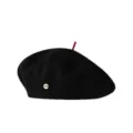 Klassische schwarze Wollberete fuer Damen mit rotem Oberteil und elegantem Metallabzeichen. - Schwarz