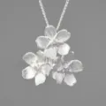 Nahaufnahme einer exquisiten S925 Silber Dreifach-Blumenanhänger Halskette mit Struktur. - Silberner Anhänger