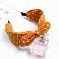Close-up detail of the mustard yellow polka dot fabric headband with a stylish knotted bow. - Yellow Polka Dot Rabbit Ears / Yellow