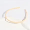 Close up of a thin plastic hair hoop in apricot color, showing delicate anti-slip teeth detail. - Regular Fit / Off White