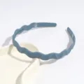 Vue détaillée d'un serre-tête en plastique ondulé bleu, accessoire minimaliste élégant. - Bleu Brume