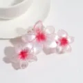 Vista detallada de pinza para el pelo con flor rosa degradada, pétalos finos y gran agarre. - Rojo