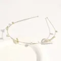 Close-up of thin gold metal hair hoop adorned with delicate pearls and sparkling rhinestones. - Y-Shape Gold