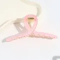 Nahaufnahme Detail einer minimalistischen rosa transparenten Haarklammer mit glänzendem Finish. - Rosa