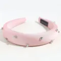 Detailed closeup of pink satin rhinestone headband, sparkly crystal accents and padded sponge. - Padded Rhinestone Style / Pink