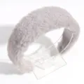 Primer plano de diadema de felpa gris, textura suave y esponjosa, accesorio para el cabello de invierno. - Gris claro