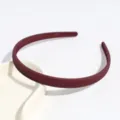 Vista dettagliata del cerchietto in plastica rosso scuro con righe diagonali, design minimal. - Borgogna