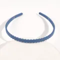 Dettaglio della fascia per capelli in plastica blu, che mostra la superficie strutturata diagonale. - Fascia Onde Blu