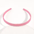 Dettaglio cerchietto rosa in plastica, sottile fascia per capelli con motivo a righe. - Cerchietto Intrecciato Rosa