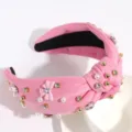 Close-up detail of the pink knotted hair hoop, featuring sparkling rhinestones and pearls. - Bow Light Pink