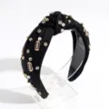 Detail view of a stylish black knotted headband adorned with pearls, rhinestones and football charms. - Black